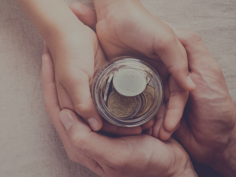 Two Hands Holding Jar With Coins