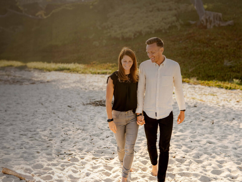 Younger Couple Walking On Beach